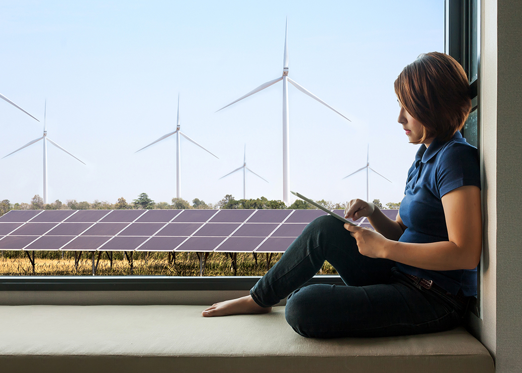 A woman sitting on a window sill with wind turbines in the background, featured in a blog post.